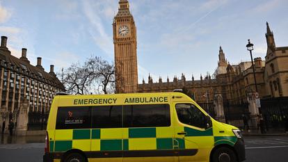 An ambulance is driven past the Houses of Parliament in central London on January 4, 2023. UK medical bodies said patients were dying due to inadequate care and urged the government to act as Britain's health service grapples with a winter crisis of strikes and soaring demand. (Photo by JUSTIN TALLIS / AFP)
