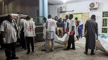 Des membres de la Croix-Rouge nigériane transportent des sacs mortuaires contenant les corps des victimes dans un hôpital de Maiduguri, à la suite des explosions qui ont frappé cette ville du nord-est du pays, située dans l’État de Borno, au Nigeria, le 16 mars 2026.