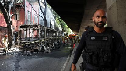 Un policier marche à côté d’un bus brûlé par des trafiquants de drogue lors d’une opération policière à Rio de Janeiro mercredi.