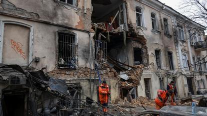 Des travailleurs communaux nettoient une zone sur le site d’un immeuble d’appartements touché par une frappe de drone russe, au milieu de l’attaque de la Russie contre l’Ukraine, à Odessa, Ukraine, le 19 mars 2026.