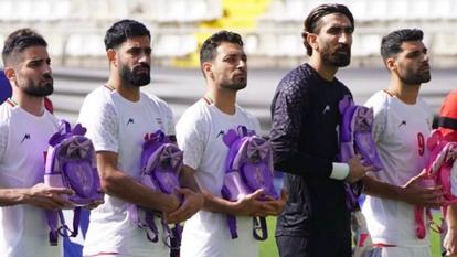 Les joueurs iraniens ont porté des brassards noirs et tenaient dans leurs bras des cartables roses et violets ornés de rubans durant leur hymne.