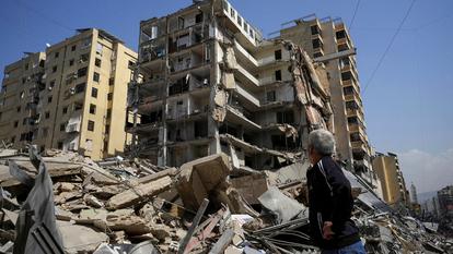 Un homme se tient près d’un bâtiment endommagé après des frappes israéliennes, dans la banlieue sud de Beyrouth, au Liban, le 12 mars.