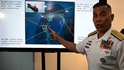 Le contre-amiral Roy Vincent Trinidad, porte-parole de la marine philippine, montre une photo sur laquelle on voit des soldats philippins saisir des bouteilles jaunes appartenant à des pêcheurs chinois, soupçonnées de contenir du cyanure, à Manille le 13 avril 2026.