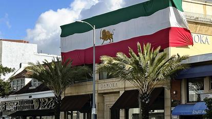 Un drapeau iranien de l’ancienne monarchie orne la façade d’une boutique de tapis dans un quartier irano-américain de Los Angeles, le 1er avril.