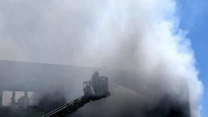 Photo d’illustration de pompiers éteignant un incendie dans un entrepôt.