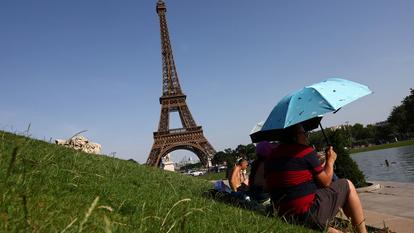 Les touristes aux abords de la tour Eiffel tentent de supporter la chaleur écrasante.