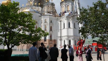 Une délégation du Crédit Agricole constate l’impact laissé par un drone russe sur la cathédrale de la Dormition à Kiev, le 15 juin 2026.