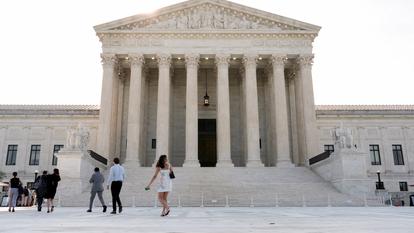 Des personnes marchent devant le bâtiment de la Cour suprême, alors que la cour s’apprête à rendre les décisions finales de son mandat de neuf mois, à Washington, D.C., États-Unis, le 30 juin 2026.