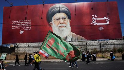 Des fidèles chiites passent devant une banderole représentant l’ayatollah Ali Khamenei, le défunt guide suprême de l’Iran, lors des commémorations de l’Achoura, le jour le plus saint du calendrier chiite, dans la banlieue sud de Beyrouth, au Liban, le 26 juin 2026.
