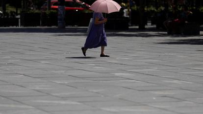 Une femme utilise un parapluie pour se protéger du soleil pendant la canicule, le 29 juin 2026.