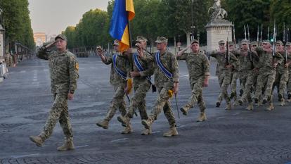 Lors d’une répétition pour le défilé du 14 Juillet, des soldats ukrainiens défilent avec leur drapeau national, jeudi 9 juillet, sur l’avenue des Champs-Élysées, à Paris.