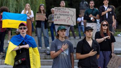 Des gens chantent l’hymne national lors d’une manifestation contre la décision du président ukrainien Volodymyr Zelensky de remplacer Mykhailo Fedorov au poste de ministre de la Défense, à Kyiv, le 16 juillet 2026.