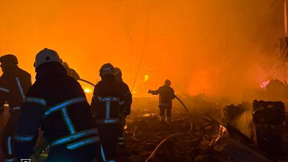 des pompiers ukrainiens en train d’éteindre un incendie sur le site d’une attaque aérienne russe à Kiev, le 16 juillet 2026.