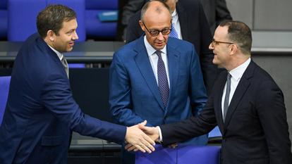 Jens Spahn (à droite) serre la main du vice-chancelier SPD Lars Klingbeil (à gauche), sous les yeux du chancelier CDU Friedrich Merz, le 9 juillet dernier au Bundestag.