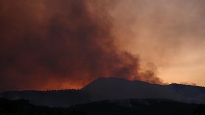 La fumée s’échappe d’un incendie de forêt au coucher de soleil près de Cotignac, dans le département du Var.