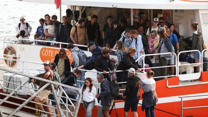 Des vacanciers de Lège-Cap-Ferret débarquent d’un bateau à leur arrivée à Arcachon, lors de l’opération d’évacuation de l’ensemble de la presqu’île du Cap-Ferret, le 24 juillet 2026.