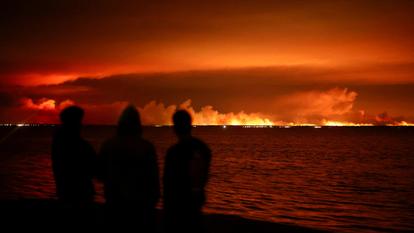 Des touristes observent l’incendie qui ravage une zone forestière près du bassin d’Arcachon, depuis Gujan-Mestras, en Gironde, le 24 juillet 2026.