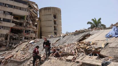 Des travailleurs utilisent un marteau-piqueur sur des débris d’un bâtiment effondré, presque un mois après que des tremblements de terre ont secoué le Venezuela le 24 juin, à La Guaira, le 22 juillet 2026.