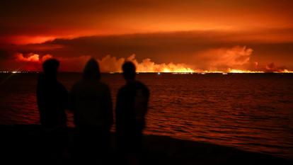 Des touristes observent depuis Gujan-Mestras l’incendie qui ravage la forêt autour du bassin d’Arcachon, en Gironde, le 24 juillet 2026.