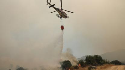 Un hélicoptère de lutte contre l’incendie déverse de l’eau à El Tiemblo, dans la province de Castilla y Leon, le 24 juillet 2026.