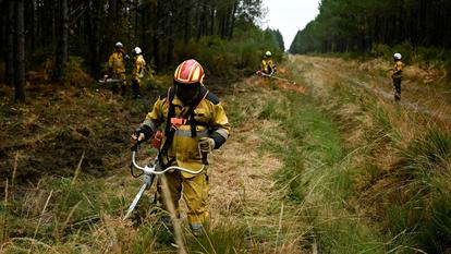 Un pompier débroussaille un terrain à Saint-Jean-d’Illac, à l’ouest de Bordeaux, le 27 juillet 2026.