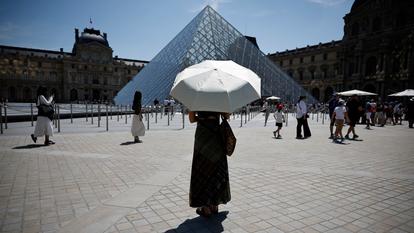 Devant la pyramide du Louvres, à Paris, lors de l’épisode caniculaire de fin mai en France.