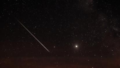 Une étoile filante face à Jupiter.