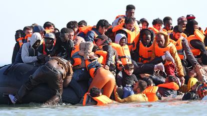 Des migrants montent à bord d’une embarcation de passeurs au large de la plage de Gravelines, dans le nord de la France, le 29 juillet.
