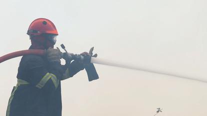 Un pompier travaille à éteindre un incendie à Le Temple, dans le département de la Gironde, le 29 juillet 2026.