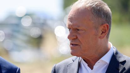 Le premier ministre polonais Donald Tusk s’adresse à la presse, près d’un cratère dans un champ laissé par un objet non identifié qui semble être un missile russe, dans la province de Lublin, Pologne, 30 juillet 2026.