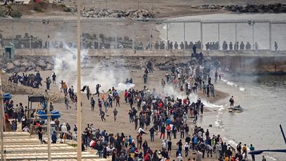 Les forces de sécurité espagnoles usant de gaz lacrymogène contre les migrants, à la frontière entre Ceuta et la ville marocaine de Fnideq, le 18 mai 2021.