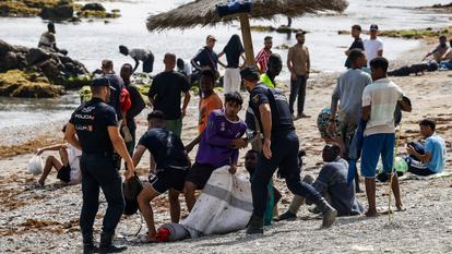 Des policiers patrouillent sur la plage alors que des migrants attendent d’entrer dans un centre de migrants de courte durée à Ceuta, en Espagne, le 1er août 2026.