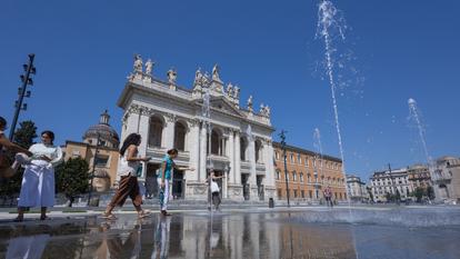 Des touristes cherchent à se rafraîchir près des jets d’eau des fontaines de la Piazza San Giovanni, à Rome, le 1er août 2026.