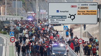 Des policiers et des soldats espagnols escortent un grand groupe de migrants vers la frontière à Ceuta, Espagne, le 1er août 2026.