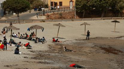 Des migrants attendent sur une plage à Ceuta, suite à des traversées massives de migrants à pied et par mer depuis le Maroc vers le territoire espagnol, à Ceuta, Espagne, le 3 août 2026.
