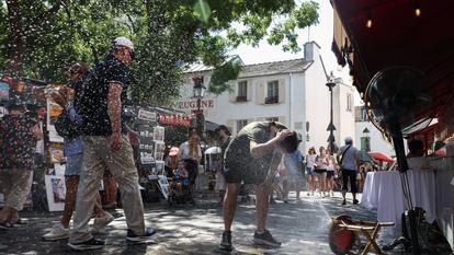 Une personne met sa tête sous une fontaine à brouillard faite maison installée par un restaurant à Montmartre pendant des températures élevées au milieu d’une canicule à Paris, France, le 12 juillet 2026.