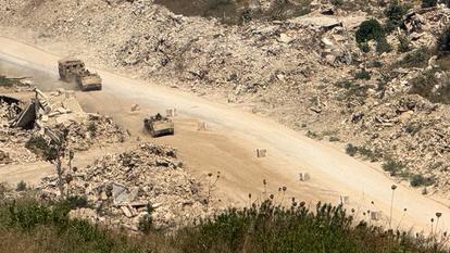 Des véhicules israéliens circulent sur une route dans le sud du Liban, vus du côté israélien de la frontière Israël-Liban, dans le nord d’Israël, le 6 août 2026.