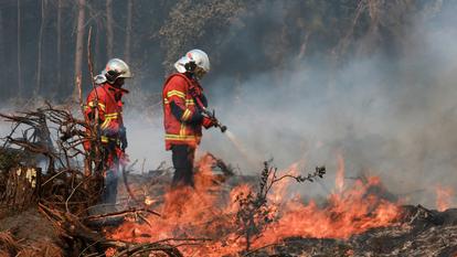 Les pompiers travaillent à éteindre un incendie de forêt à Luglon, dans le département des Landes, France, le 14 août 2026.