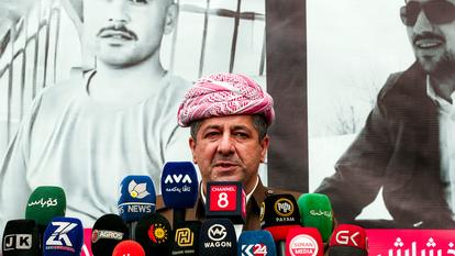 Masrour Barzani, premier ministre du gouvernement régional autonome du Kurdistan irakien, vêtu du costume traditionnel des Peshmergas kurdes, donne une conférence de presse dans la ville kurde de Soran, près de la frontière iranienne, le 25 mars 2026.