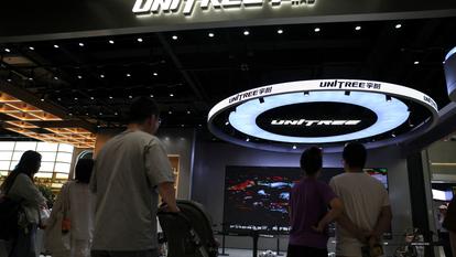 Des personnes regardent un robot GO2 de Unitree se produire dans un magasin Unitree à Pékin, le 1er août 2026.