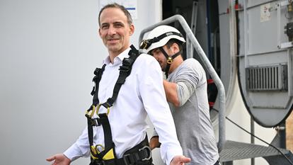 Raphaël Glucksmann, harnaché d’un baudrier, s’apprête à entrer dans une éolienne à Saint-Jean-de-Liversay, dans l’ouest de la France, le 25 août 2026.