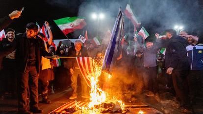 Des Iraniens brûlent des drapeaux américains et israéliens, à Téhéran, le 17 mars 2026.