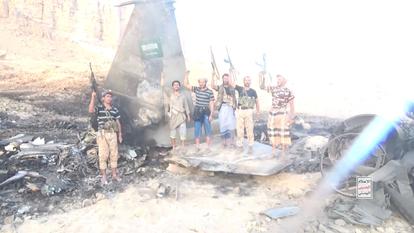 Des combattants houthis se tiennent devant ce qu’ils disent être un avion saoudien abattu, à un endroit donné comme étant le Yémen, dans cette image fixée d’une vidéo diffusée le 16 septembre 2026.