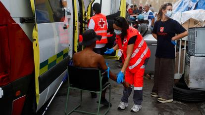 Des membres de la Croix-Rouge espagnole aident un migrant blessé dans une zone industrielle, suite au passage massif de migrants en provenance du Maroc, à Ceuta, en Espagne, le 21 septembre 2026.