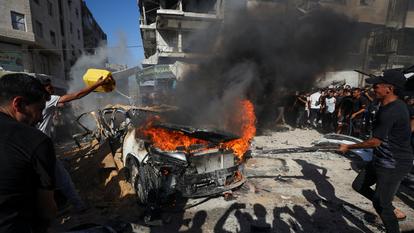 Des Palestiniens tentent d’éteindre un incendie à la suite d’une frappe aérienne israélienne qui a touché un véhicule dans la ville de Gaza, le 19 septembre 2026.