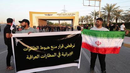 Des manifestants tiennent une banderole et un drapeau iranien lors d’une manifestation contre les restrictions américaines visant les activités aériennes iraniennes et leur impact sur les vols entre l’Iran et l’Irak, devant l’aéroport international de Nadjaf (Irak), le 28 septembre 2026.