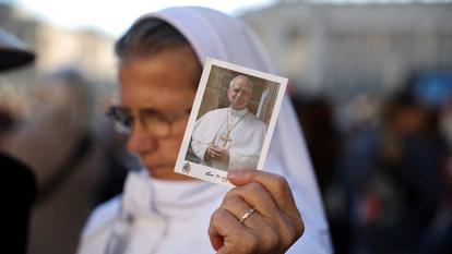 Une religieuse tenant une image du pape sur la place Saint-Pierre, au Vatican, au lendemain de l’opération du Saint-Père pour un cancer pulmonaire.