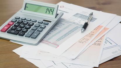 Calculatrice et stylo sur des relevés bancaires. (Image d’illustration)