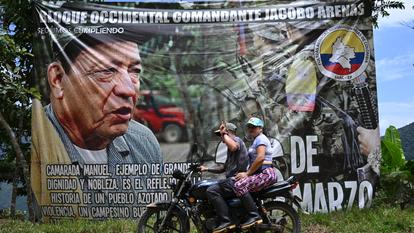 Une moto passe devant une banderole à l’effigie de Manuel Marulanda Vélez, fondateur et ancien dirigeant des Forces armées révolutionnaires de Colombie (FARC).