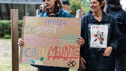 Une femme brandit une pancarte sur laquelle l’on peut lire «Vous appelez ça du sport ? Nous, on appelle ça un meurtre», lors d’une manifestation contre la chasse, le 21 août 2026.
